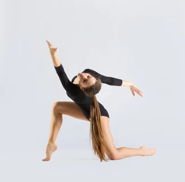 Молодая девушка занимается художественной гимнастикой — стоковое фото