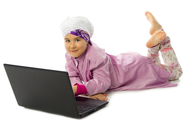 Маленькая девочка в традиционной мусульманской одежде с ноутбуком
