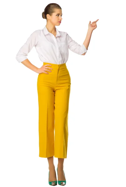 Woman in yellow pants shows pointing gesture Stock Image