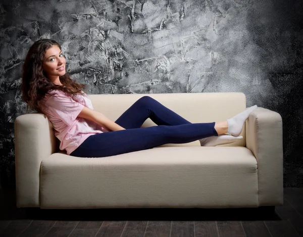 Girl on sofa at dark room — Stock Photo, Image