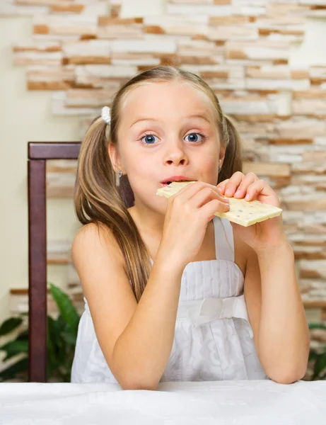 Kleines Mädchen isst eine Schokolade — Stockfoto