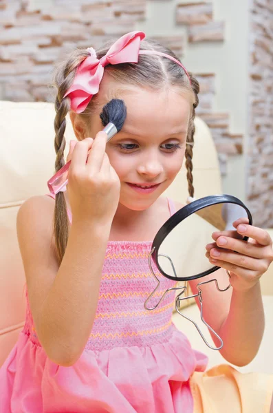 Маленькая девочка делает макияж — стоковое фото
