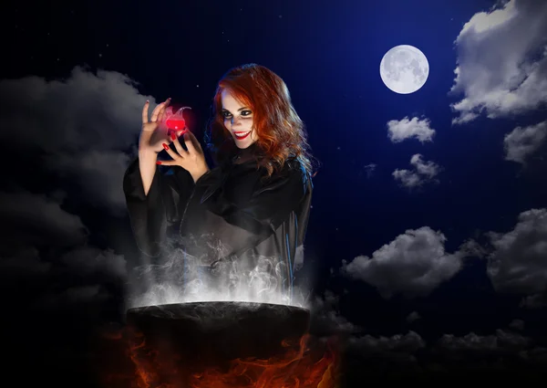 Bruxa com poção vermelha e caldeirão sobre fundo céu noturno — Fotografia de Stock