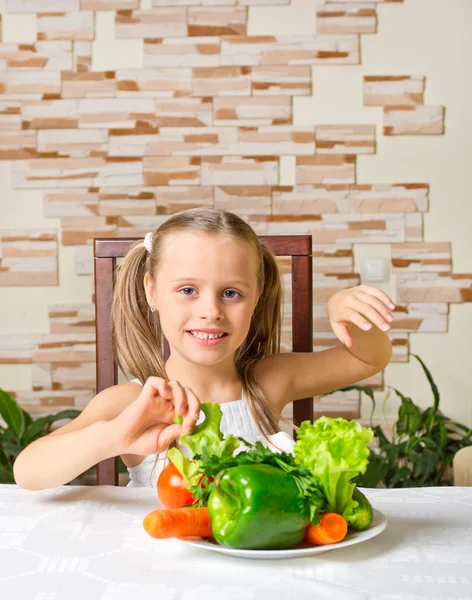Маленькая девочка ест овощи — стоковое фото