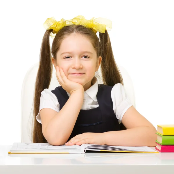Маленькая школьница за столом — стоковое фото