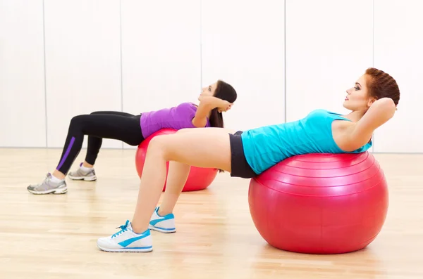 Two young girls doing gymnastic exercises — Stock Photo, Image