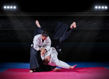 Fight between martial arts fighters at sports hall clipart