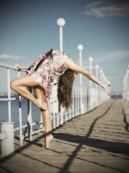 Chica joven haciendo ejercicios de gimnasia en el muelle (ver antiguo ) — Foto de Stock