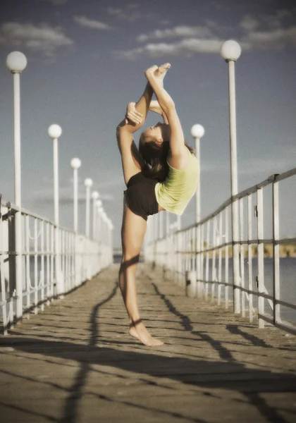 Chica joven haciendo ejercicios de gimnasia en el muelle (ver antiguo ) — Foto de Stock