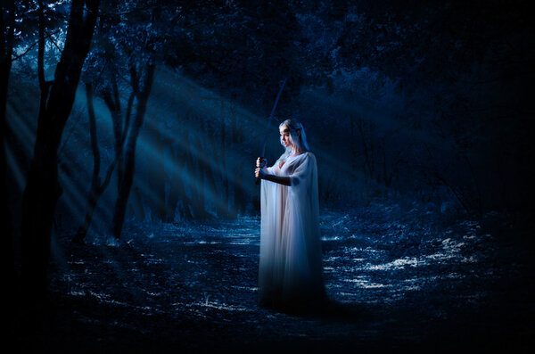 Young elven girl in night forest