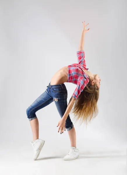 Молодая танцующая девушка в джинсах — стоковое фото