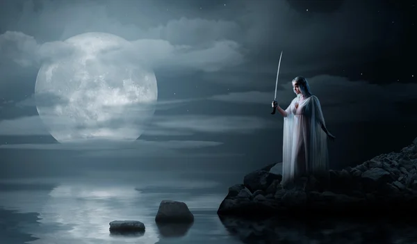 Elf kızı gece deniz kıyısında kılıçla — Stok fotoğraf