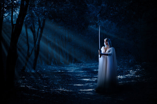 Young elven girl with sword isolated in night forest