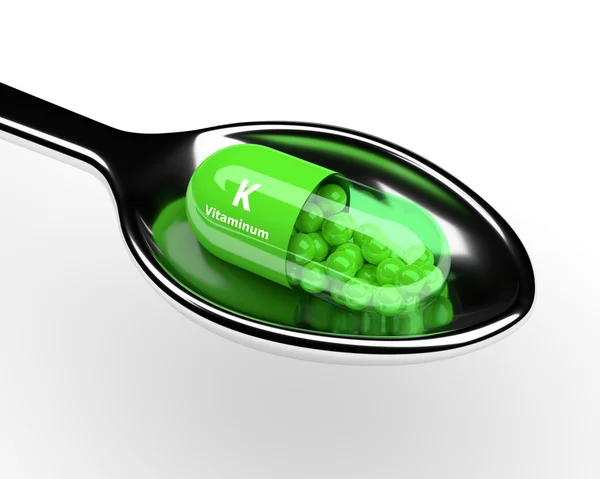 3d vitamina K píldora en cuchara sobre blanco — Foto de Stock