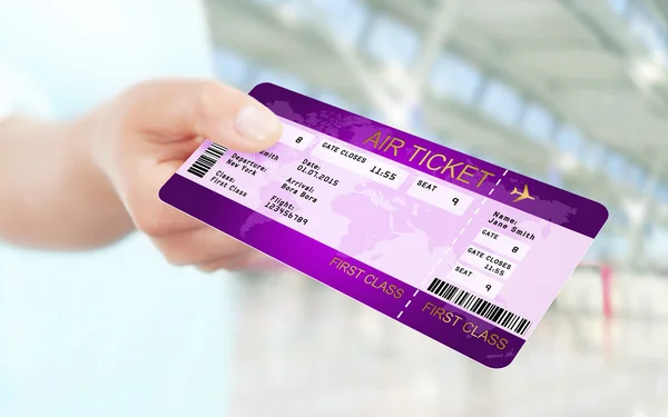 Mão segurando bilhete aéreo no aeroporto — Fotografia de Stock