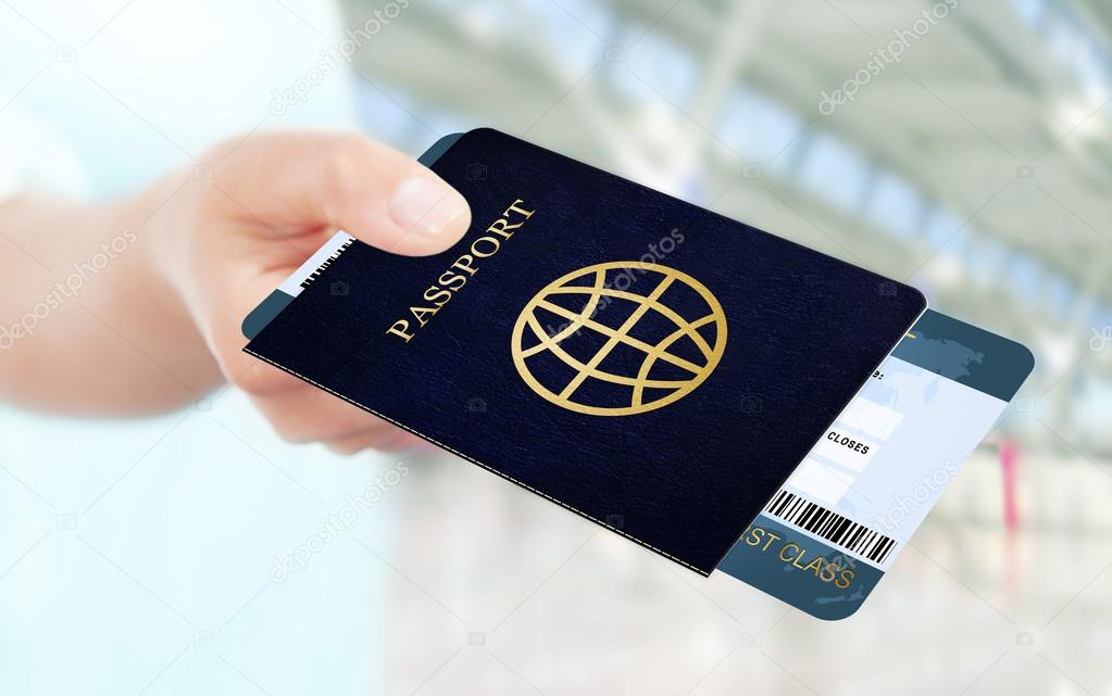 hand holding air ticket and passport on airport