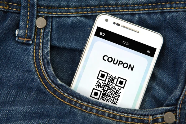 Mobiele telefoon met korting coupon in zak — Stockfoto