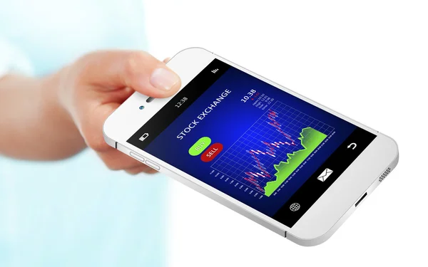 Mão segurando telefone celular com gráfico de bolsa de valores sobre branco — Fotografia de Stock