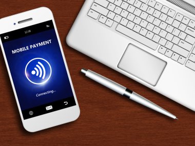 Mobil ödeme, dizüstü bilgisayar ve ahşap masa üzerine kalem ile telefon