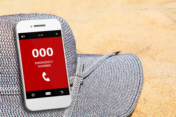 Mobile phone with emergency number 000 on the beach — Stock Photo, Image