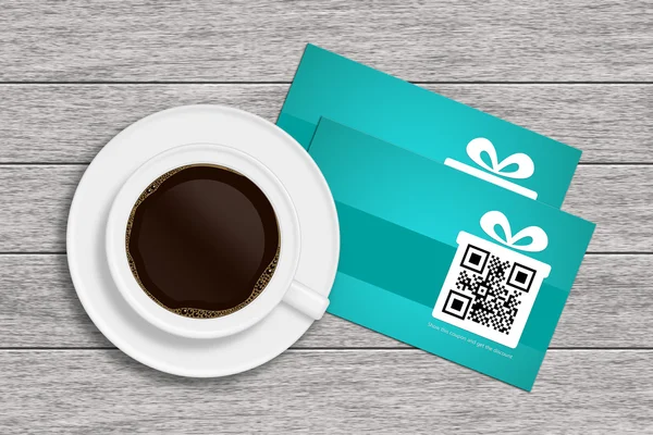 Rabattgutscheine mit QR-Code und Tasse Kaffee auf Holztisch — Stockfoto