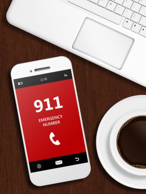 Masanın üzerinde yatan 911 acil durum numarası ile cep telefonu