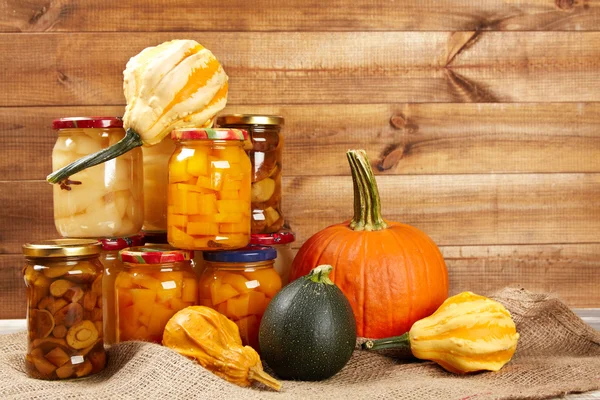 Verduras de otoño conservadas en estantería en pared de madera —  Fotos de Stock