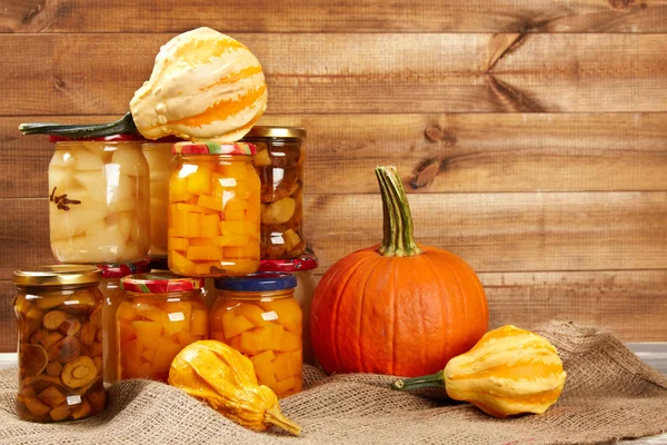 Verduras de otoño conservadas en estantería en pared de madera —  Fotos de Stock