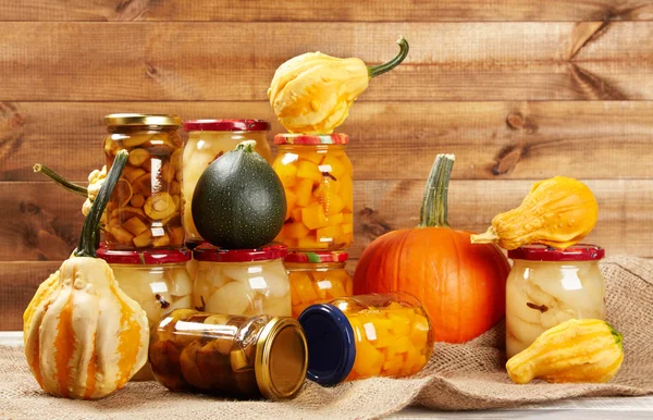 Verduras de otoño conservadas en estantería en pared de madera — Foto de Stock