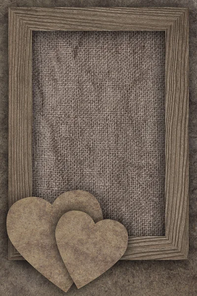 Twee harten en frame op oude houten plank — Stockfoto