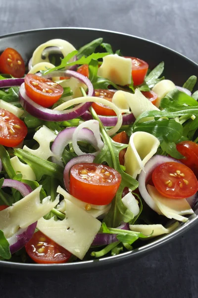 Salada com rúcula, queijo, tomate e cebola vermelha — Fotografia de Stock