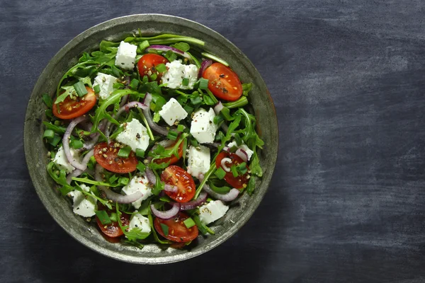 Salad with arugula, tomato, cheese and red onion Stock Photo