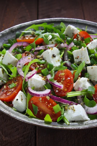 Salad with arugula, tomato, cheese and red onion Stock Image