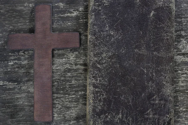 Wooden cross and old leather on old wooden board — Stock Photo, Image