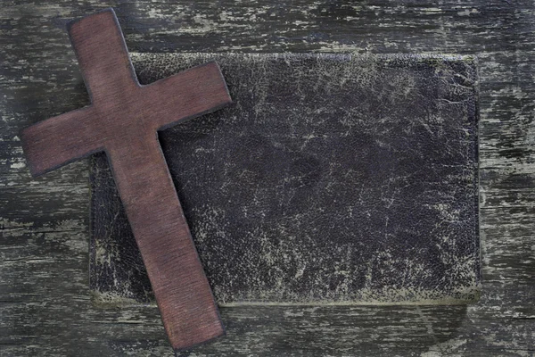 Houten kruis en oude leer op oude houten bord — Stockfoto