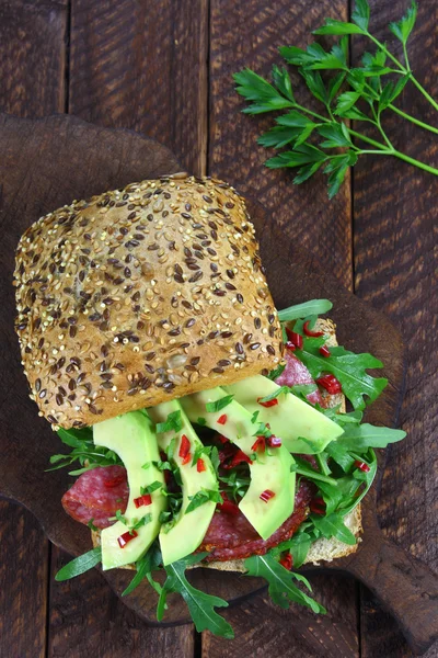 Sandwich with arugula, salami and avocado — Stock Photo, Image