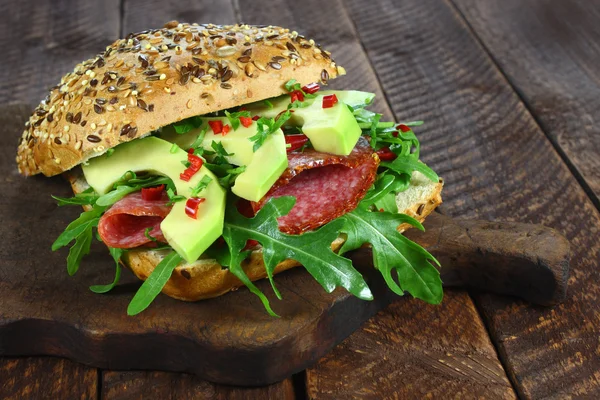 Sandwich with arugula, salami and avocado Stock Photo