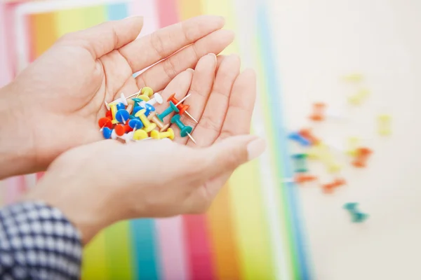 Hands with colorful pushpins — Stock Photo, Image