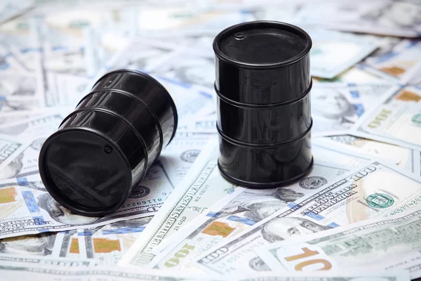 Нефтяные бочки на фоне доллара США — стоковое фото