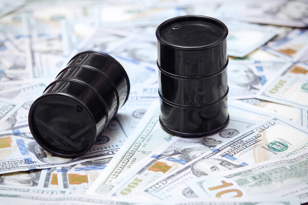 Нефтяные бочки на фоне доллара США
