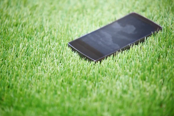 Smartphone v trávě — Stock fotografie