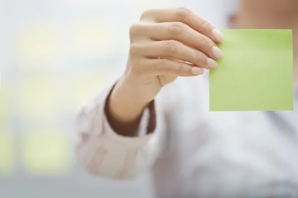 Hand of woman holding sticky note with empty space — Stock Photo, Image