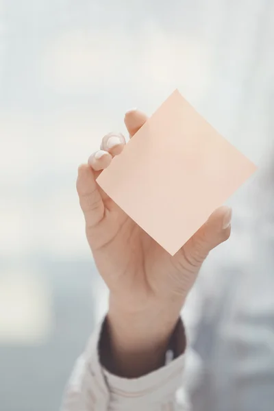 Hand van vrouw met kleverige nota met lege ruimte — Stockfoto