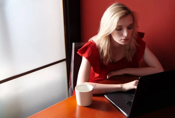 Kırmızı Tulum Giyen Dizüstü Bilgisayar Kullanan Genç Bir Kadın — Stok fotoğraf