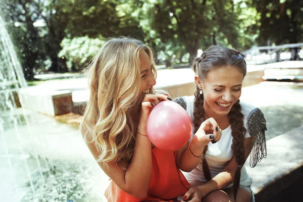 Two Girlfriends Having Fun Blowing Balloons — kuvapankkivalokuva