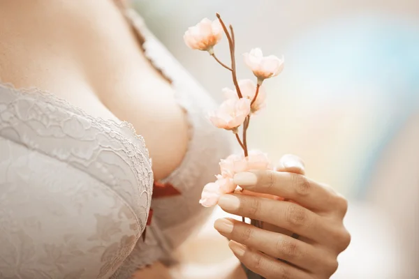 Woman in brassiere holding Sakura flower Royalty Free Stock Images