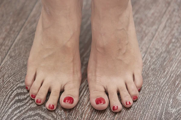 Kvinnliga fötter på träets yta — Stockfoto