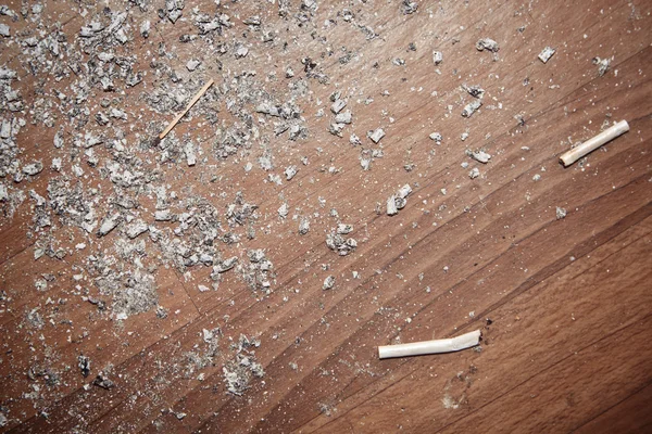 Zigarettenasche auf einem Hartholzboden — Stockfoto