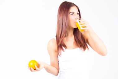 Portakal suyu içme ve turuncu elinde tutan genç kadın. Sağlıklı yaşam tarzı.