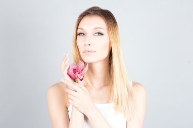 Pembe çiçek ve kalıcı makyaj ile sarışın bir kadın. Güzellik kadını.